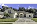 Inviting exterior showcasing arched windows, lush landscaping, and a brick driveway at 2425 Rambling Oaks Way, Kissimmee, FL 34746