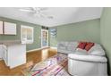 Cozy living room featuring a ceiling fan, a large sofa, and a view of the backyard at 247 S Marydell Ave, Deland, FL 32720