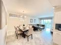 Open-concept living room and dining area with modern furnishings and lots of natural light at 3120 Paradox Cir # 101, Kissimmee, FL 34746