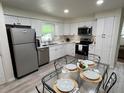 Modern eat-in kitchen with white cabinets, stainless steel appliances, and updated countertops at 3131 Lowndes Dr, Winter Park, FL 32792
