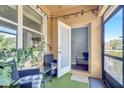 Inviting screened-in patio with two chairs, a glass table, and ambient lighting, leading to a door and interior staircase at 3166 Rodrick Cir, Orlando, FL 32824