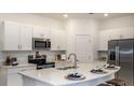 Modern kitchen featuring stainless steel appliances, white cabinetry, an island and stylish countertops at 3535 Mayfair St, Kissimmee, FL 34758