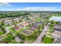 An aerial view of a suburban neighborhood featuring a lake, playground, and well-maintained homes and yards at 4729 Spindletree Ln, Orlando, FL 32829