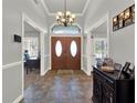 Inviting foyer featuring tile floors, a decorative chandelier, and a wooden double-door entrance at 4916 Winwood Way, Orlando, FL 32819