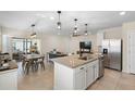 Open kitchen featuring stainless steel appliances, granite counters, and a breakfast bar overlooking the living area at 5298 Royal Point Ave, Kissimmee, FL 34746