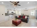 Bright living space featuring tile flooring, an elegant ceiling fan, and comfortable seating next to the kitchen at 5298 Royal Point Ave, Kissimmee, FL 34746