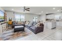 Open-concept living room featuring tile floors, a ceiling fan, and a large sectional couch for comfort at 5329 Royal Point Ave, Kissimmee, FL 34746