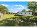 Expansive backyard with lush green grass, mature trees, and a view of the home's rear facade at 5402 Kingswood Dr, Orlando, FL 32810