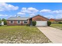 Charming brick home featuring a well-maintained lawn and attached two-car garage at 549 Mcneal Dr, Deltona, FL 32725