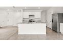 Open-concept kitchen with a central island, stainless steel appliances, white cabinets, and tile flooring at 715 Chinoy Rd, Davenport, FL 33837
