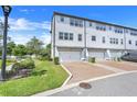 View of the back of the townhouses, featuring two car garages and landscaped walkways and gardens at 7772 Sweet Star Avenue, Orlando, FL 32836