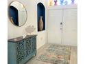 Inviting entryway with decorative blue furniture, a modern mirror and a neutral-toned area rug at 8023 King Palm Cir, Kissimmee, FL 34747