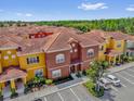 Aerial view of colorful townhomes, showcasing red tile roofs and ample parking at 8972 Coco Palm Rd, Kissimmee, FL 34747