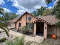 Inviting home with desert landscaping, featuring a fresh brown roof, artful sun decor, and charming front entry at 913 Red Fox Rd, Altamonte Springs, FL 32714