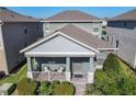 Charming single-Gathering home featuring a cozy front porch with stylish outdoor seating and landscaped front yard at 9432 Komika Ln, Winter Garden, FL 34787