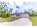 Attractive single-story home with a wide driveway leading to an attached two-car garage at 13 Oak Trail Pl, Ocala, FL 34472