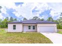 Inviting single-story home with a well-manicured lawn and an attached two-car garage at 13 Oak Trail Pl, Ocala, FL 34472
