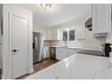 Modern kitchen with stainless steel appliances, white cabinets, stone countertops, and wood-look floors at 16336 Old Cheney Hwy, Orlando, FL 32833