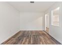 Minimalist living room with white paneling, hardwood floors, and open access to other areas of the home at 16336 Old Cheney Hwy, Orlando, FL 32833