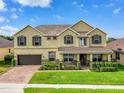 Inviting two-story home with a manicured lawn, shrubbery, and a two-car garage at 1802 Candlenut Cir, Apopka, FL 32712