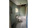 Bathroom featuring a toilet, bathtub, window, and damaged walls, needing renovation at 1905 S Westmoreland Dr, Orlando, FL 32805
