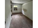 Bedroom featuring hardwood floors, a window with natural light, and built-in shelving, awaiting remodeling at 1905 S Westmoreland Dr, Orlando, FL 32805