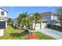 Charming single-story home features a two-car garage, palm trees, and manicured landscaping at 211 Southbridge Cir, Kissimmee, FL 34744