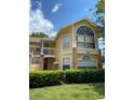 Charming two-story condo with bright yellow exterior, brick pillars, and large windows at 2442 Sweetwater Club Cir # 43, Kissimmee, FL 34746