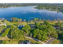 Scenic aerial view of a lakefront property featuring mature trees and a well-manicured lawn at 2926 Marquesas Ct, Windermere, FL 34786
