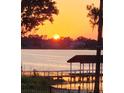 Picturesque waterfront view featuring a dock and the sunset over the calm water at 2926 Marquesas Ct, Windermere, FL 34786