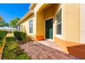 Inviting front entrance with a dark green door, beautiful brick walkway, and well-maintained landscaping at 3205 Sonesta Ct # F, Clermont, FL 34711
