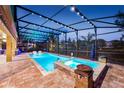 Enclosed pool and spa featuring a brick surround, colorful lighting, and black metal enclosure at 427 Egret Place Dr, Winter Garden, FL 34787