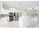 Bright kitchen with stainless steel appliances, white cabinetry, an island and a view into a separate room at 453 Kettering Rd, Deltona, FL 32725