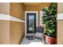 Cozy front porch featuring a comfortable chair, potted plants, and a decorative front door at 484 Harbor Winds Ct, Winter Springs, FL 32708