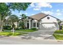 Inviting single-Gathering home with a manicured lawn and tropical landscaping creating an inviting curb appeal at 5112 Jetsail Dr, Orlando, FL 32812