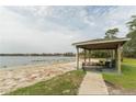 Picturesque lakeside beach area with a picnic shelter, perfect for outdoor gatherings at 5999 Lake Pointe Dr # 602, Orlando, FL 32822