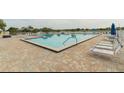 Large community pool with tiled deck and lounge chairs for relaxing by the water at 5999 Lake Pointe Dr # 602, Orlando, FL 32822