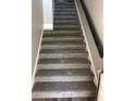 Carpeted staircase with modern railing leading to the upper level of the home at 5999 Lake Pointe Dr # 602, Orlando, FL 32822