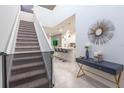 Inviting foyer with staircase, modern console table, and an open view into the kitchen area at 7352 Oakmoss Loop, Davenport, FL 33837