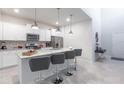 Bright, modern kitchen with granite countertops, stainless steel appliances, and a spacious island with bar stools at 7352 Oakmoss Loop, Davenport, FL 33837
