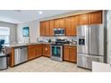 Kitchen features stainless steel appliances, granite countertops, and warm wood cabinetry at 7660 Ripplepointe Way, Windermere, FL 34786