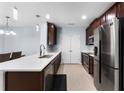 Modern kitchen with stainless steel appliances, white countertops, and dark wood cabinets at 812 Marcel Loop, Davenport, FL 33837
