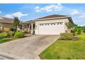 Inviting single-story home featuring a two-car garage, well maintained lawn, and charming front porch at 8205 Sw 78Th Terrace Rd, Ocala, FL 34476