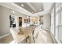 Open dining room with tray ceiling, pendant lights, and view of spiral staircase at 8638 Finsen St, Orlando, FL 32827