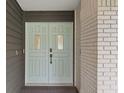 Charming exterior shot of the front door, featuring a light blue color, windows, and gray brick at 1012 Willa Lake Cir, Oviedo, FL 32765