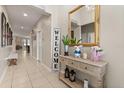 Inviting hallway featuring neutral walls, tile flooring, and a decorative console table at 1199 Playa Del Sol Ln, St Cloud, FL 34771