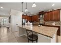 Stylish kitchen featuring granite countertops, pendant lights, and stainless steel appliances at 1199 Playa Del Sol Ln, St Cloud, FL 34771