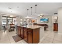 Open-concept kitchen island with granite countertops, pendant lighting, and stainless steel appliances at 1199 Playa Del Sol Ln, St Cloud, FL 34771