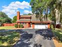 Front exterior showcasing a two-car garage and a lovely brick-colored facade at 12030 Kirby Smith Rd, Orlando, FL 32832
