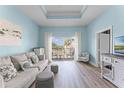 Cozy living room with tray ceilings, wood floors, and bright natural light at 1322 Seven Eagles Ct # 301, Reunion, FL 34747